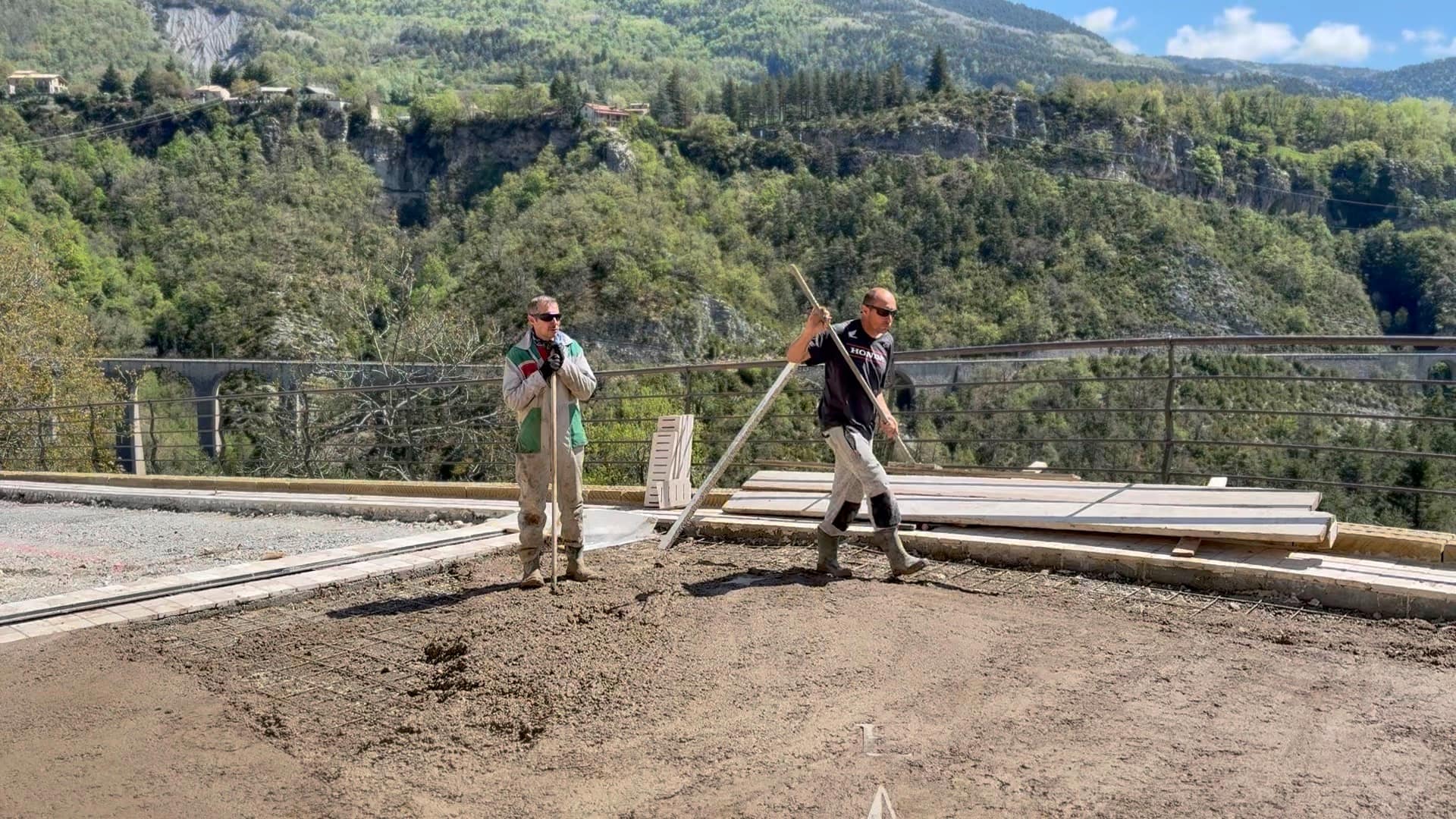 Olivier et Franck Masse terminent une terrasse, la vallée et son viaduc en arrière-plan.