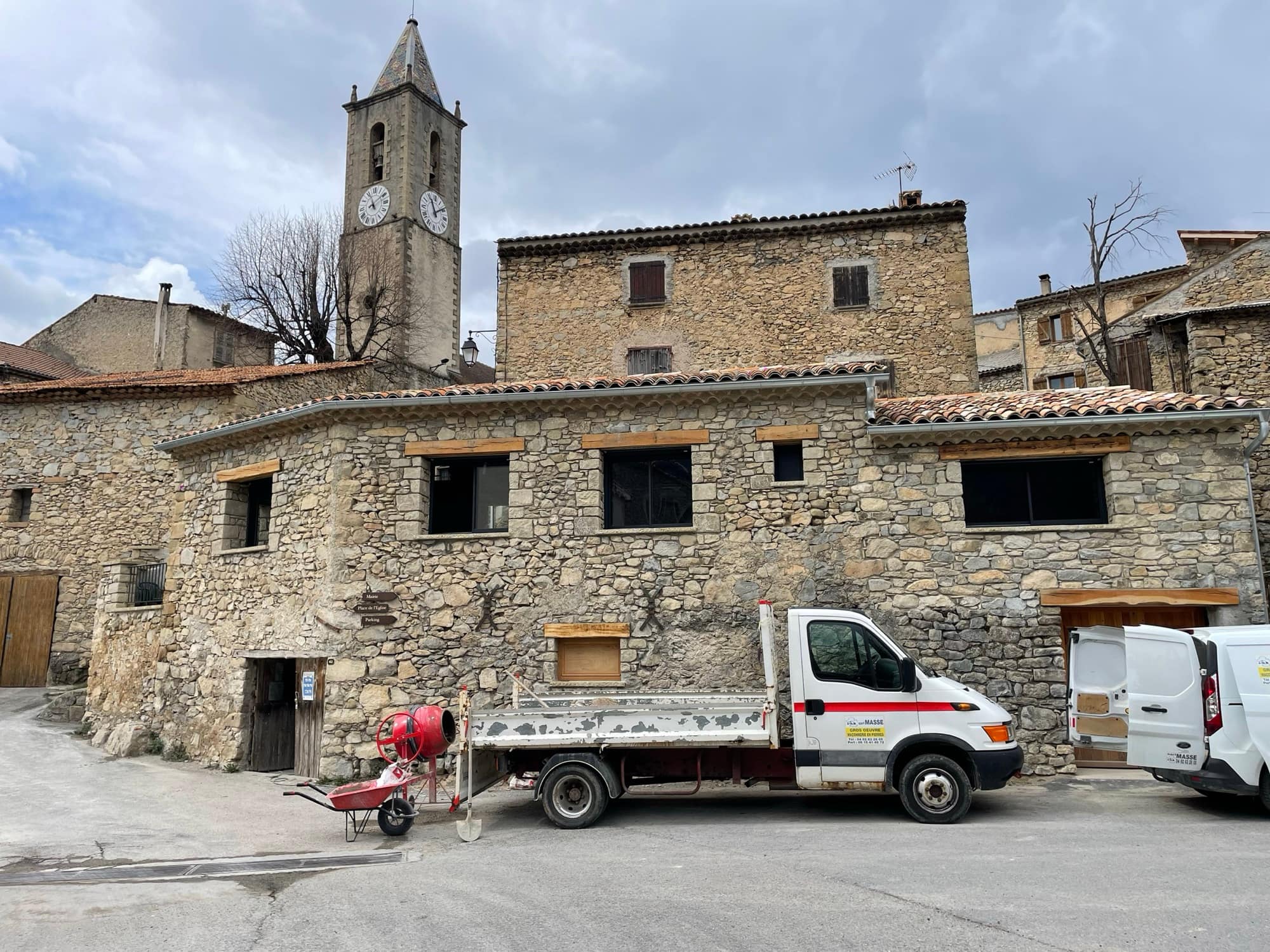 Maison en pierre entièrement remontée : maçonneries reprises, toiture refaite, linteaux neufs. Le camion et la bétonnière de la SARL MASSE devant le chantier.