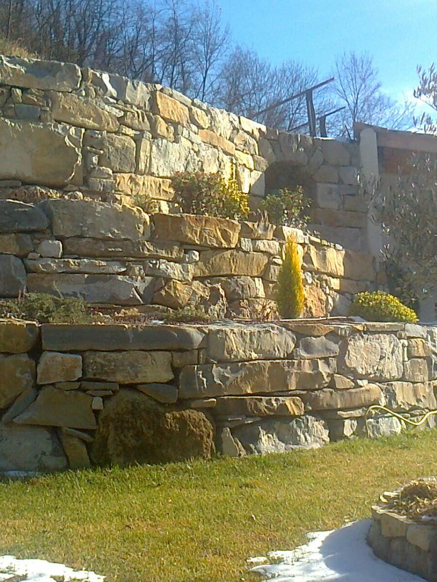 Murs de soutènement en pierre étagés sur plusieurs niveaux, plantations en terrasses.